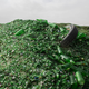 A tire hides in a hill made of green glass bottles.